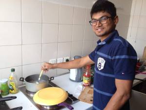 A boy cooking in the kitchen room and smiling